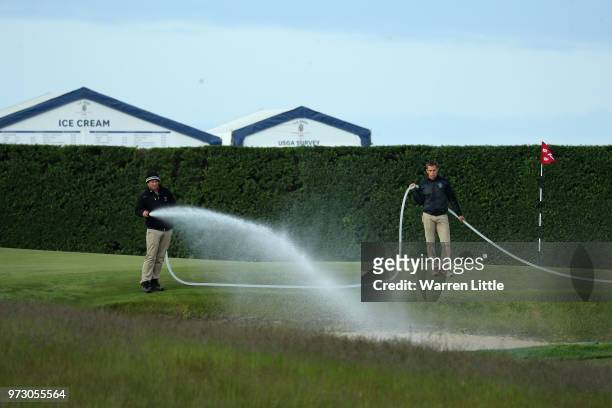The grounds crew water a green during a practice round prior to the 2018 U.S. Open at Shinnecock Hills Golf Club on June 13, 2018 in Southampton, New...