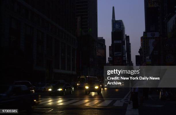 Times Square is plunged into darkness as the sun goes down after a massive power failure caused the largest power outage in the nation's history,...