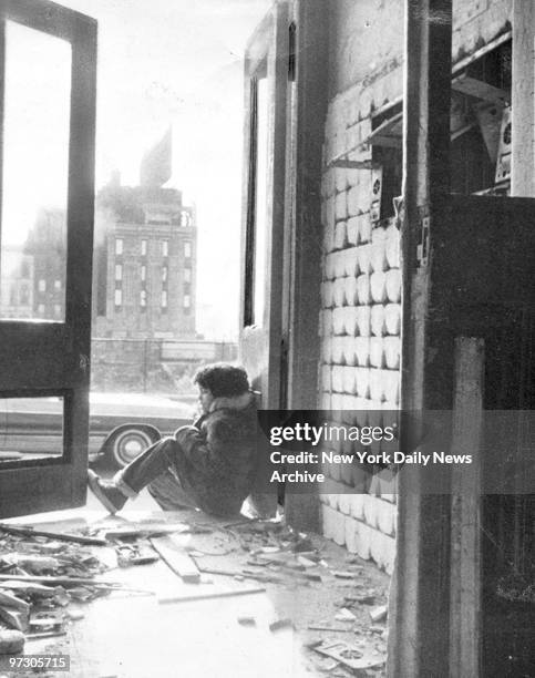 Child sits in doorway of rundown building at 135th St and Willis Ave. In the South Bronx