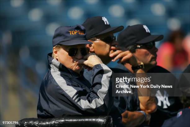 New York Yankees' owner George Steinbrenner, who wears a cap that reads "Top Gun," manager Joe Torre and bench coach Lee Mazzilli watch their players...