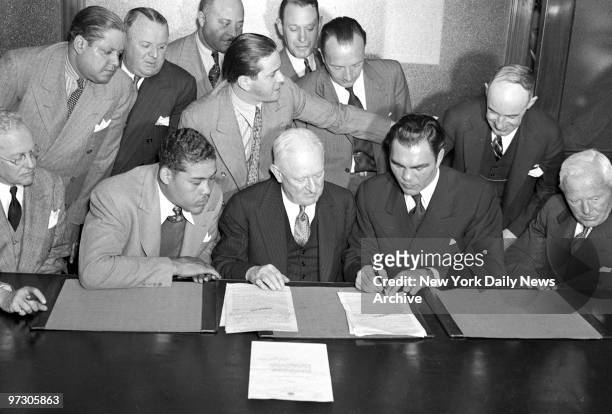 Max Schmeling signs for fight with Joe Louis on June 22 at Yankee Stadium as Gen. Phelan and Louis look on.