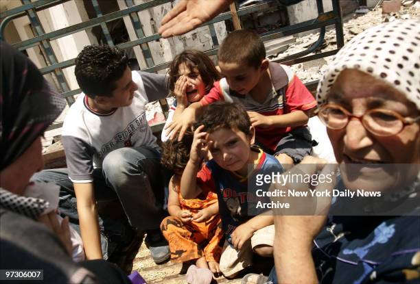 Children cry as they are loaded into trucks in Aitaroun, Lebanon, only a few miles from the border with Israel, to flee their village after spending...
