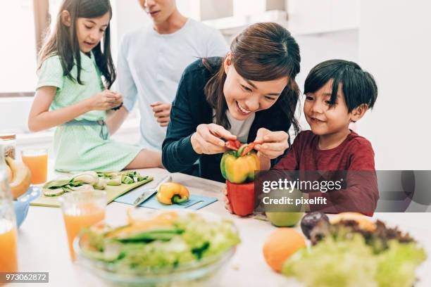 preparing salad with kids is fun - asian family cooking stock pictures, royalty-free photos & images