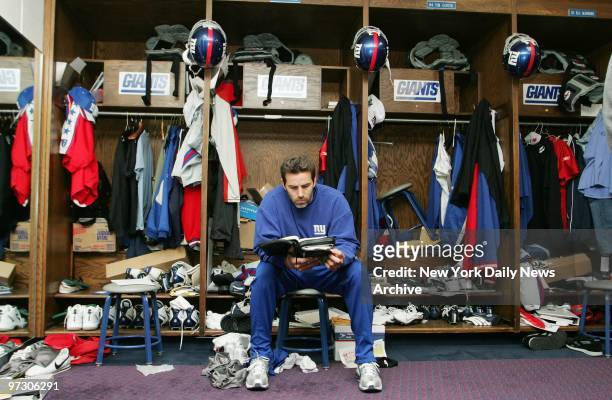 New York Giants' quarterback Kurt Warner gets in a little reading during a quiet moment in the Giants Stadium locker room. Warner is expected to be...