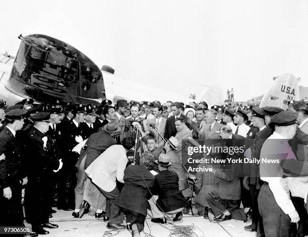 Tired, hungry, unshaven but triumphant, Howard Hughes and his crew of four are brought to the microphone after landing at Floyd Bennett Field....