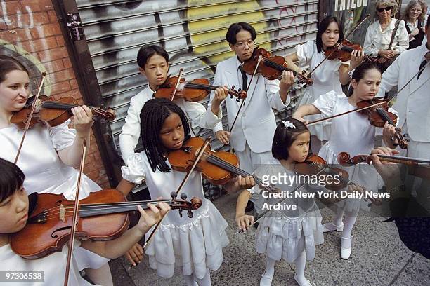 Children play violins outside Old St. Patrick's Cathedral during memorial service for John F. Kennedy Jr., his wife, Carolyn Bessette Kennedy, and...