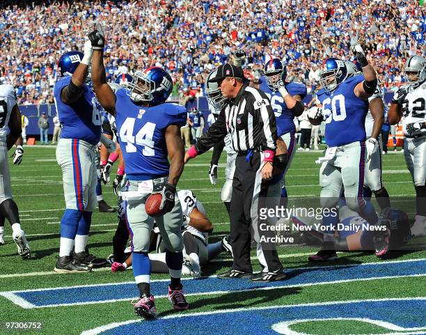 New York Giants running back Ahmad Bradshaw points the way as he scorese Big Blue's first two TDs, showing no sign of ankle pain in rout of Raiders.