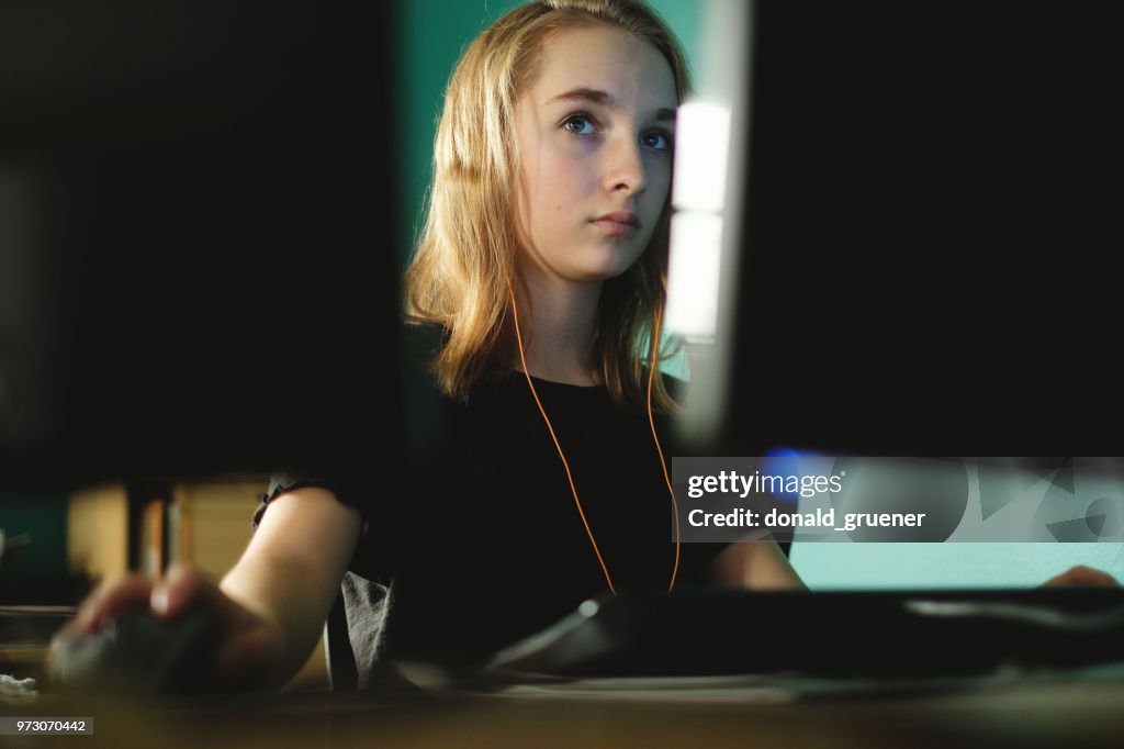 Teenage girl working or gaming on computer