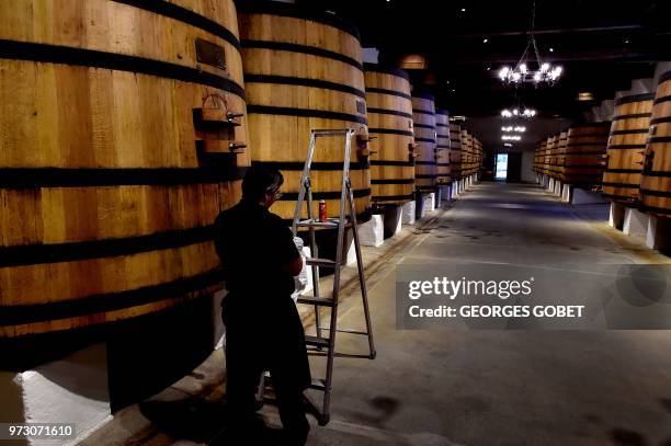 This photo taken on June 11, 2018 shows an employee working in the Chateau Margaux' vat in Margaux, near Bordeaux, western France. - The Chateau...