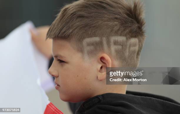 Young fan with "FIFA" shaved into his hair during a training session as part of the England media access at Spartak Zelenogorsk Stadium ahead of the...