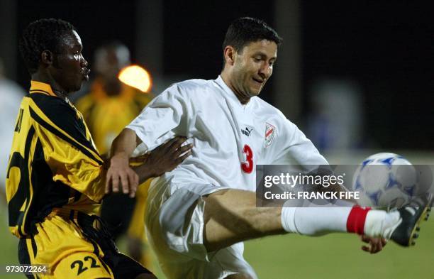 Tunisian Zoubeir Baya is challenged by Zambian Misheck Lungu, 21 January 2002 at Modibo Keita stadium in Bamako, during their 2002 African Nations...