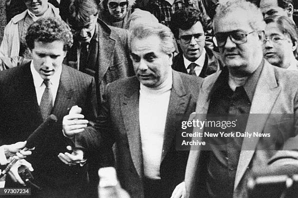 John Gotti is surrounded by reporters as he leaves courthouse with his brother Peter .