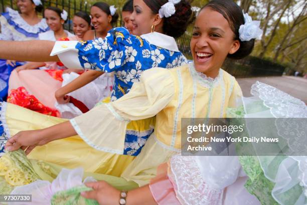 Dancers with Centro Civico Cultural Dominica of Queens swing their skirts and chat before performing during the Hispanic Music Festival at Thomas...