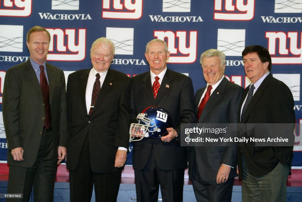Tom Coughlin holds a New York Giants's helmet as he is intro