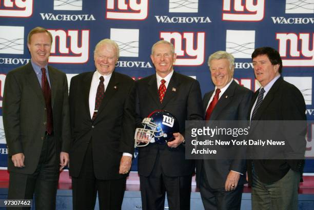 Tom Coughlin holds a New York Giants's helmet as he is introduced as the team's new head coach at Giants Stadium in the Meadowlands. On hand are...