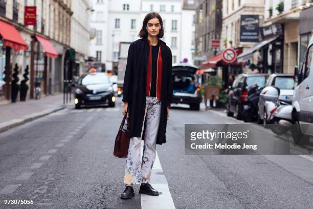 Model Celine Delaugere wears a long black jacket, pants with splattered paint during Paris Fashion Week Spring/Summer 2018 on September 26, 2017 in...