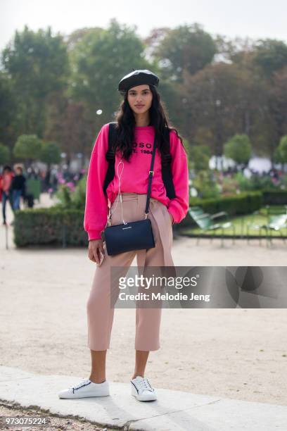 Brazilian model Aira Ferriera wears a black beret, hot pink Philosophy sweatshirt, light pink capri pants, a Michael Kors bag, and white Tory Sport...