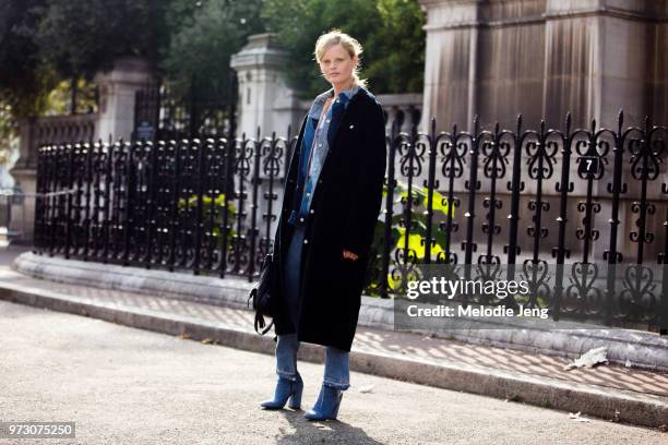 Model Hanne Gaby Odiele wears a long jacket, patchwork denim jacket, jeans, and denim boots after the Dries Van Noten show during Paris Fashion Week...