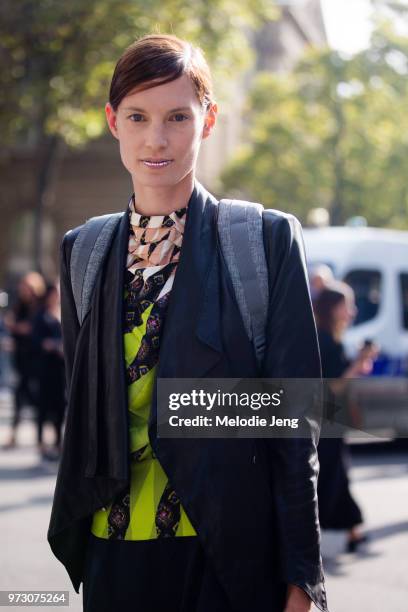 Model Iris Strubegger exits the Dries Van Noten show in the jeweled lip makeup, a blazer, and colorful print Dries Van Noten top during Paris Fashion...