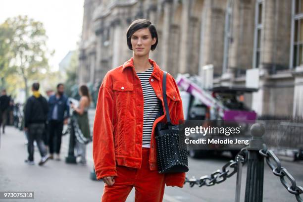 Model Marte Mei Van Haaster exits the Dries Van Noten show in matching red jacket and pants, a striped shirt, and black Paco Rabanne chain-mail...