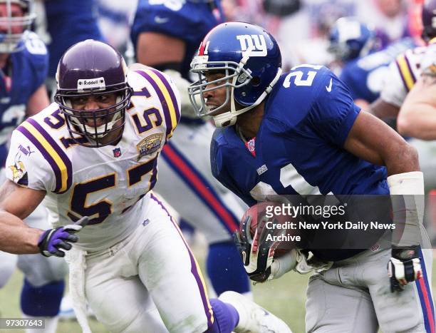 New York Giants' Tiki Barber carries the ball as the Minnesota Vikings' Dwayne Rudd gives chase at NFC Championship Game between the Giants and the...