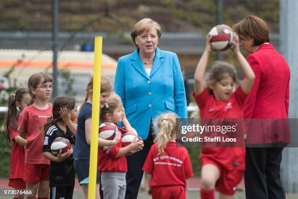 German Chancellor Angela Merkel looks on as young girls train during a program to encourage integration of children with foreign roots through...