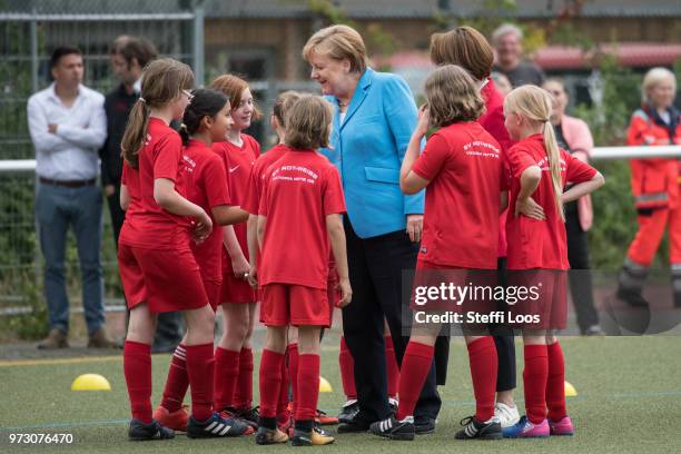 German Chancellor Angela Merkel talkes to young girls during a visit of a program to encourage integration of children with foreign roots through...