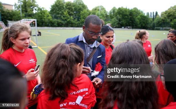 Former German National player Cacau signs autographs during his visit of a program to encourage integration of children with foreign roots through...