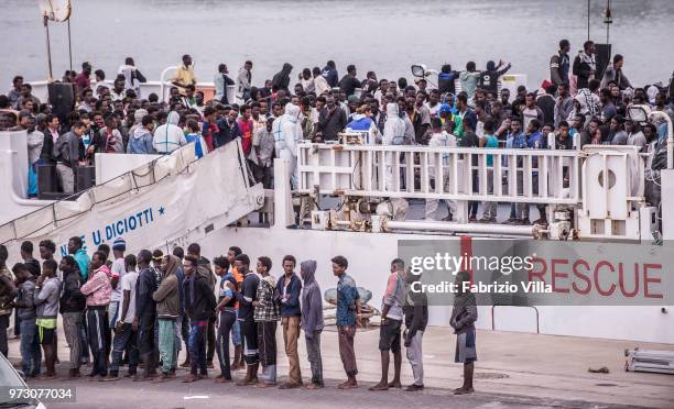 Migrants disembark the Italy's coastguard ship Diciotti at the port of Catania on June 13, 2018 in Catania, Italy. The Diciotti ship carried 932...