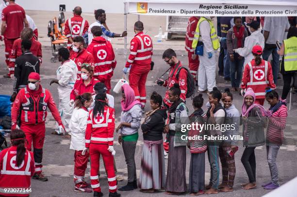 Migrants disembark the Italy's coastguard ship Diciotti at the port of Catania on June 13, 2018 in Catania, Italy. The Diciotti ship carried 932...