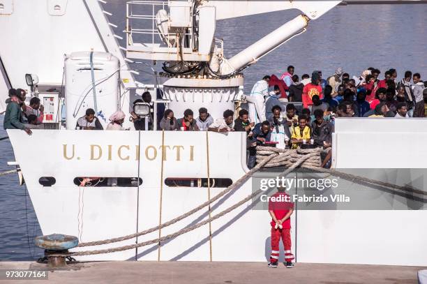 Migrants disembark the Italy's coastguard ship Diciotti at the port of Catania on June 13, 2018 in Catania, Italy. The Diciotti ship carried 932...