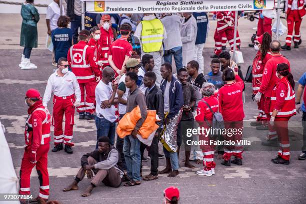 Migrants disembark the Italy's coastguard ship Diciotti at the port of Catania on June 13, 2018 in Catania, Italy. The Diciotti ship carried 932...