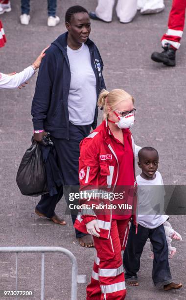 Migrants disembark the Italy's coastguard ship Diciotti at the port of Catania on June 13, 2018 in Catania, Italy. The Diciotti ship carried 932...