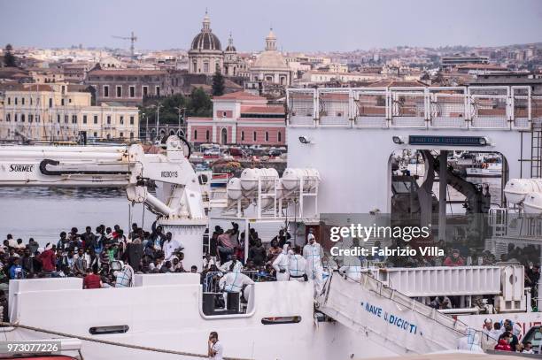 Migrants disembark the Italy's coastguard ship Diciotti at the port of Catania on June 13, 2018 in Catania, Italy. The Diciotti ship carried 932...