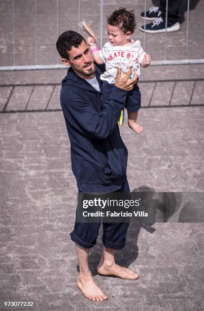 Migrants disembark the Italy's coastguard ship Diciotti at the port of Catania on June 13, 2018 in Catania, Italy. The Diciotti ship carried 932...