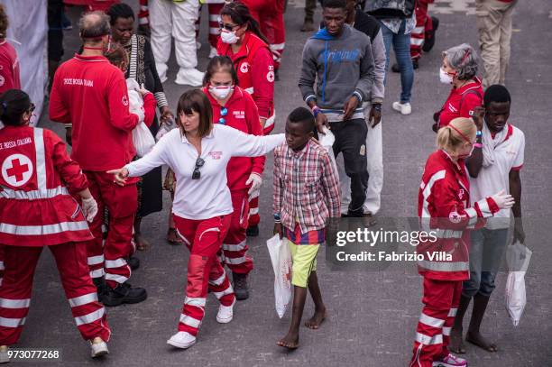 Migrants disembark the Italy's coastguard ship Diciotti at the port of Catania on June 13, 2018 in Catania, Italy. The Diciotti ship carried 932...