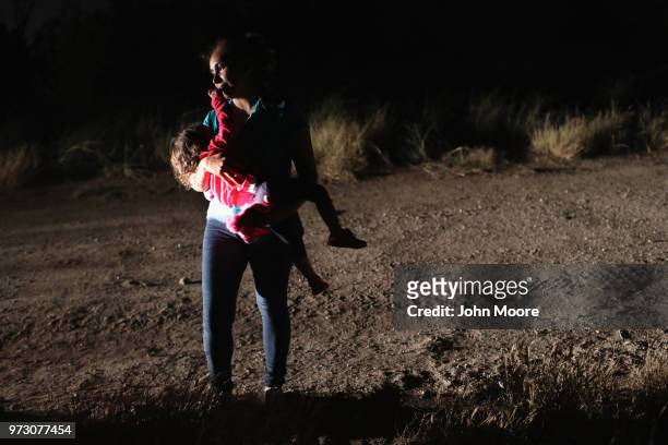 Honduran mother holds her two-year-old daughter while being detained by U.S. Border Patrol agents near the U.S.-Mexico border on June 12, 2018 in...