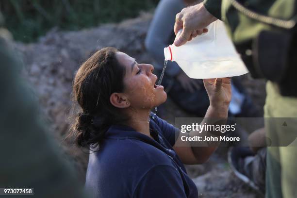 An undocumented immigrant is given water by U.S. Border Patrol agents after she was aprehended in a sugarcane field near the U.S.-Mexico Border on...