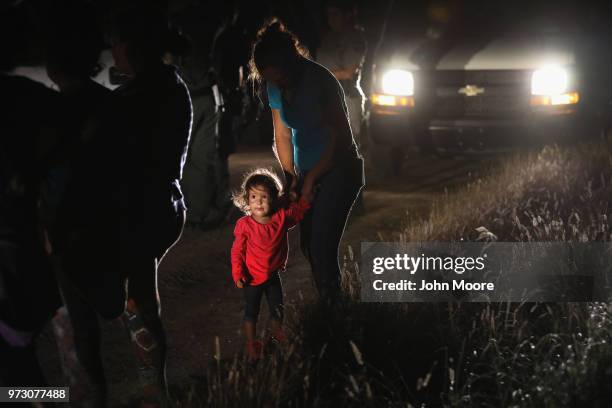 Two-year-old Honduran stands with her mother after being detained by U.S. Border Patrol agents near the U.S.-Mexico border on June 12, 2018 in...