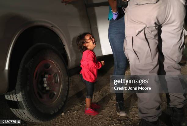 Two-year-old Honduran asylum seeker cries as her mother is searched and detained near the U.S.-Mexico border on June 12, 2018 in McAllen, Texas. The...