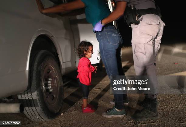 Two-year-old Honduran asylum seeker cries as her mother is searched and detained near the U.S.-Mexico border on June 12, 2018 in McAllen, Texas. The...