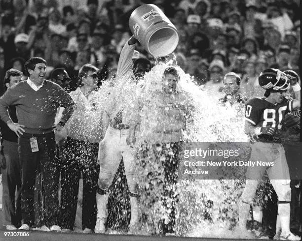 New York Giants vs Denver Broncos in Superbowl XXI. One more victory shower, courtesy of Harry Carson, doesn't bother Giants coach Bill Parcells at...