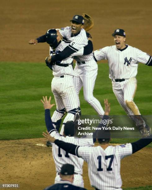 New York Yankees' pitcher Mariano Rivera , catcher Jorge Posada and Scott Brosius celebrate the final out of Game 4 and sweep of the Atlanta Braves...