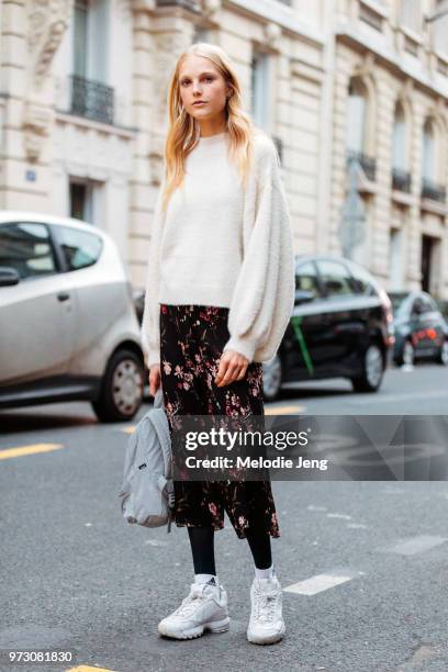 Belgian model Kirin Dejonckheere wears an oversized white sweater, black floral skirt, and white chunky sneakers during Paris Fashion Week...