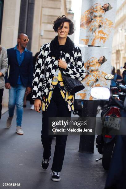 Dutch model Marte Mei Van Haaster wears a black and white patterned fur jacket, black Paco Rabanne Chain-Mail Bucket Bag, floral top, black pants,...