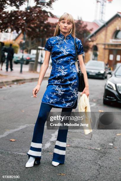 Model/Actress Klara Kristin wears a blue qipao Chinese dress, blue flare pants with stripes, and white heels after Balenciaga during Paris Fashion...