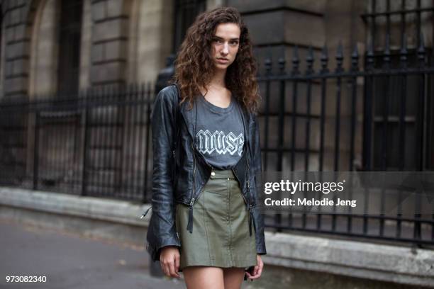 Model Zwaan Bijl wears a black leather jacket, "Muse" tshirt, and green leather skirt after the Givenchy show during Paris Fashion Week Spring/Summer...