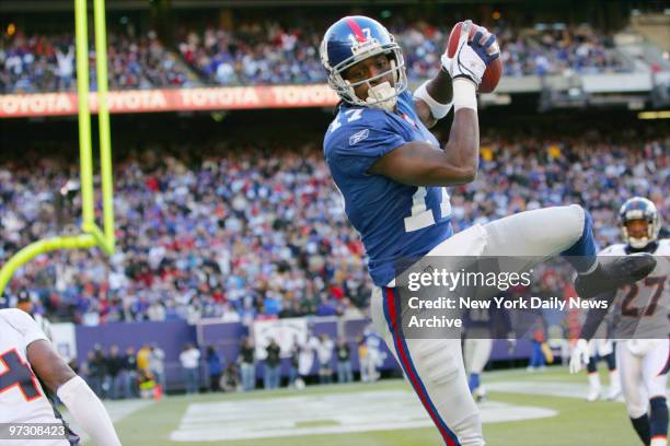 New York Giants' wide receiver Plaxico Burress catches the ball for a touchdown in the first quarter against the Denver Broncos at Giants Stadium....