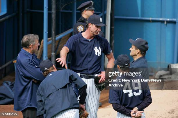 New York Yankees' pitcher Randy Johnson speaks with manager Joe Torre as pitching coach Ron Guidry and team physician Stuart Hershon look on during a...