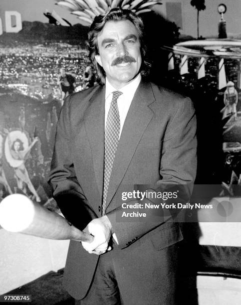 Tom Selleck displays bat he presented to Planet Hollywood